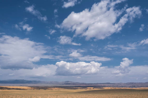 istock Cloudy sky over the steppe and desert mountains on hot summer day 1540056134