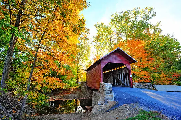 Photo of Autumn colors frame a covered bridge in Maryland