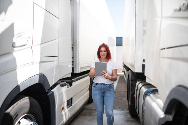 istock Trucker lifestyles, Red-haired trucker woman works with orders. Using technology and applications for delivery 1540066872