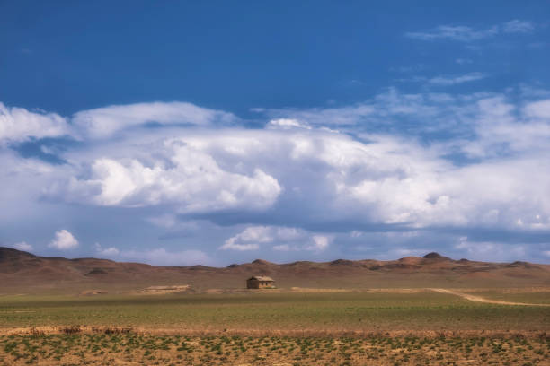 small lonely clay house in the desert under a cloudy sky