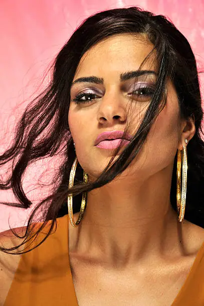 Portret of a beautiful black haired female in very warm colors. The eyes are in focus and the hair is for parts in movement.