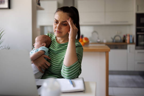 Tired and worried mother working at home