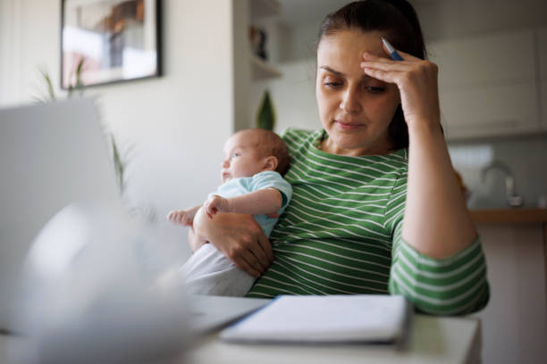 Madre stanca e preoccupata che lavora a casa - foto stock