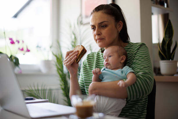 mother working at home office - eating sandwich emotional stress food imagens e fotografias de stock