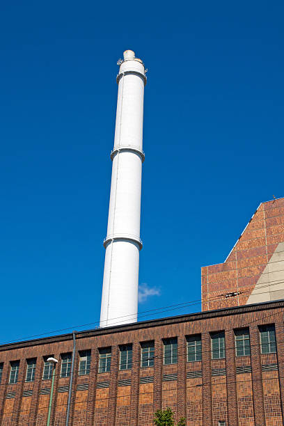 smokestack y edificio de ladrillo blanco - schwerindustrie fotograf�ías e imágenes de stock