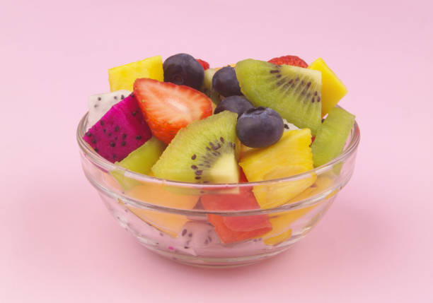 istock Fruit salad in glass bowl on pink background 1540086649