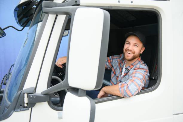 close up of truck driver behind steering wheel. copy space. - postal worker truck driver delivering delivery person imagens e fotografias de stock
