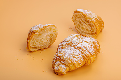 Good morning concept. Fresh croissants with cream filling and almond flakes. Sweet dessert, deconstruction, selective focus, flat lay, copy space