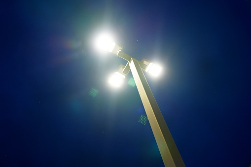 LED street lamp post after sundet on blue background in nature