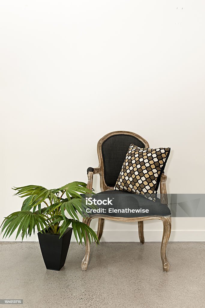 Antique armchair and plant near wall Antique armchair furniture with houseplant against white wall Antique Stock Photo