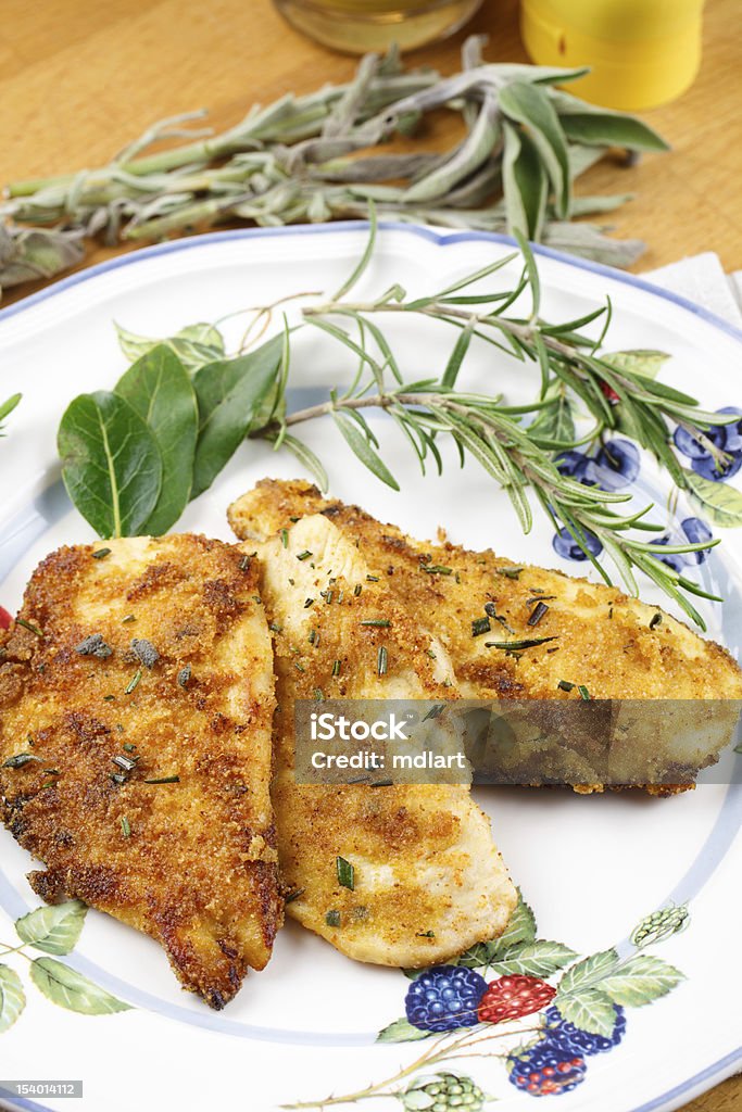 Marinated chicken with herbs Delicious slices of chicken breast, marinated in herbs and decorated with herbs leafs and sprigs. Served in a country stile setup Barbecue - Meal Stock Photo