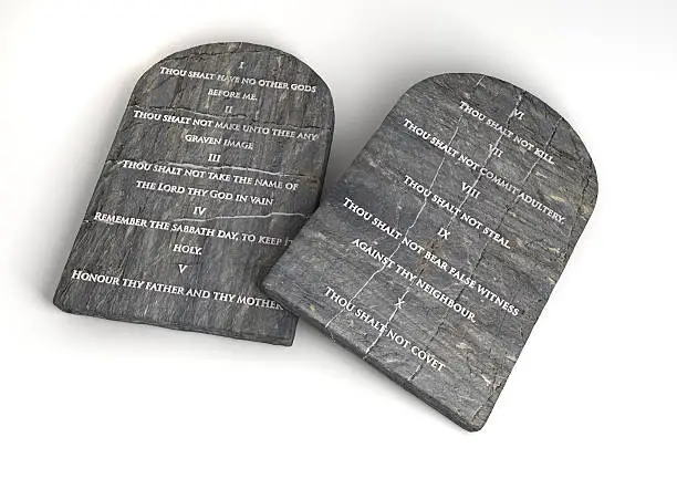 Two stone tablets with the ten commandments inscribed on them on an isolated background.