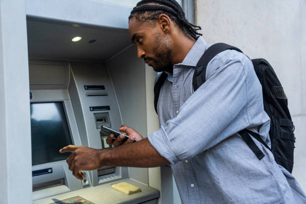 istock African American man using ATM while holding smart phone 1540157680