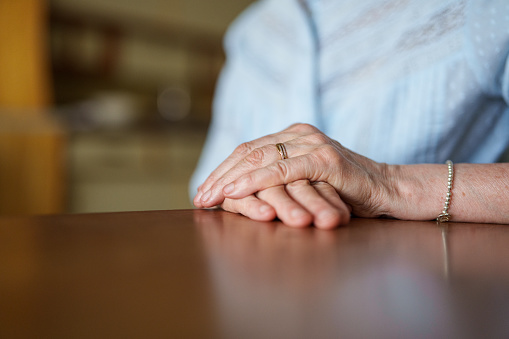 Close up of senior woman's hands resting on table