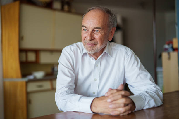 istock Senior man sitting at kitchen table with hands clasped 1540161178