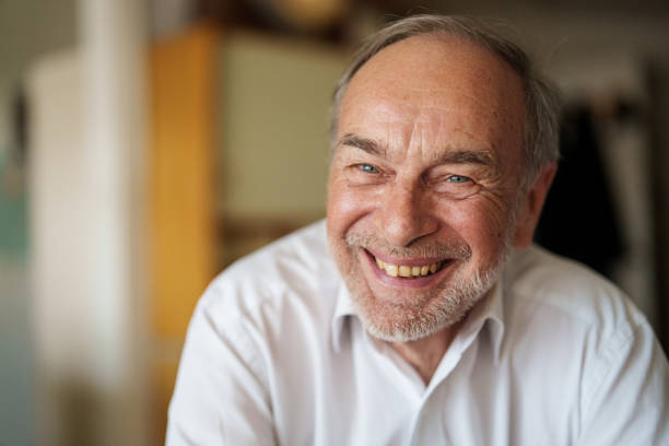 istock Cheerful senior man looking and smiling at the camera while standing indoors 1540161247