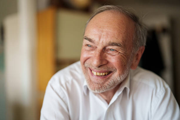 istock Senior man sitting indoors while laughing and looking away 1540161526