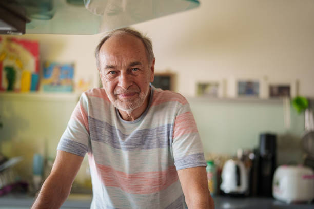 istock Senior man looking at the camera while standing indoors 1540161815