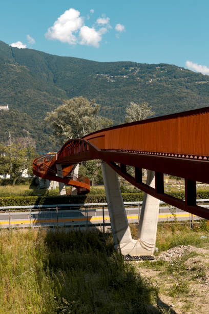 moderno ponte pedonale e ciclabile arrugginito con il fiume ticino che scorre sotto. splendido panorama, immerso nelle alpi della svizzera italiana - balaustrade foto e immagini stock