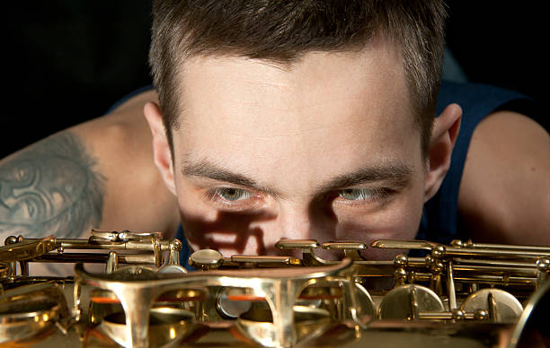 Plano de jazz de jovem homem olhar em Saxofone - fotografia de stock