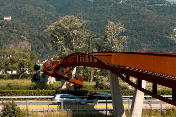 moderno ponte pedonale e ciclabile arrugginito con il fiume ticino che scorre sotto. splendido panorama, immerso nelle alpi della svizzera italiana - balaustrade foto e immagini stock