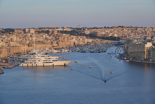Valetta, Malta - June 7, 2023: View across the Grand Harbour at sunset from Upper Barrakka Gardens to Birgu and Senglea in Malta