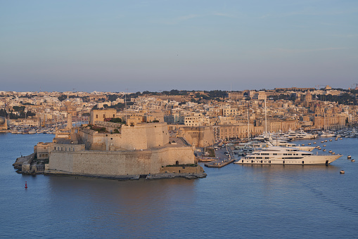 Valetta, Malta - June 7, 2023: View across the Grand Harbour at sunset from Upper Barrakka Gardens to Birgu and Senglea in Malta