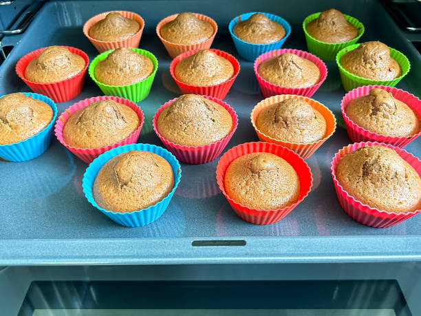istock Chocolate muffins in colorful silicone molds on baking sheets in the oven 1540190219