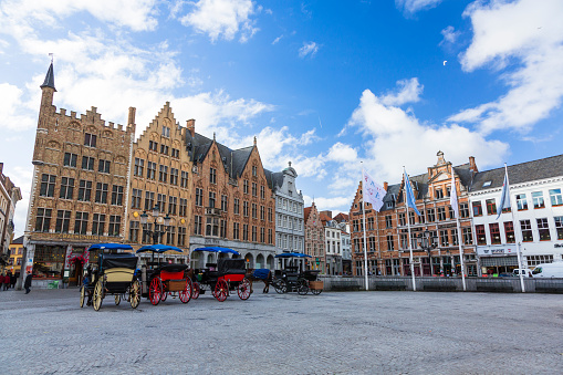 Bruges, Belgium - July 10, 2022: Tourists enjoying the Grote Markt in Bruges, Belgium on a sunny day.