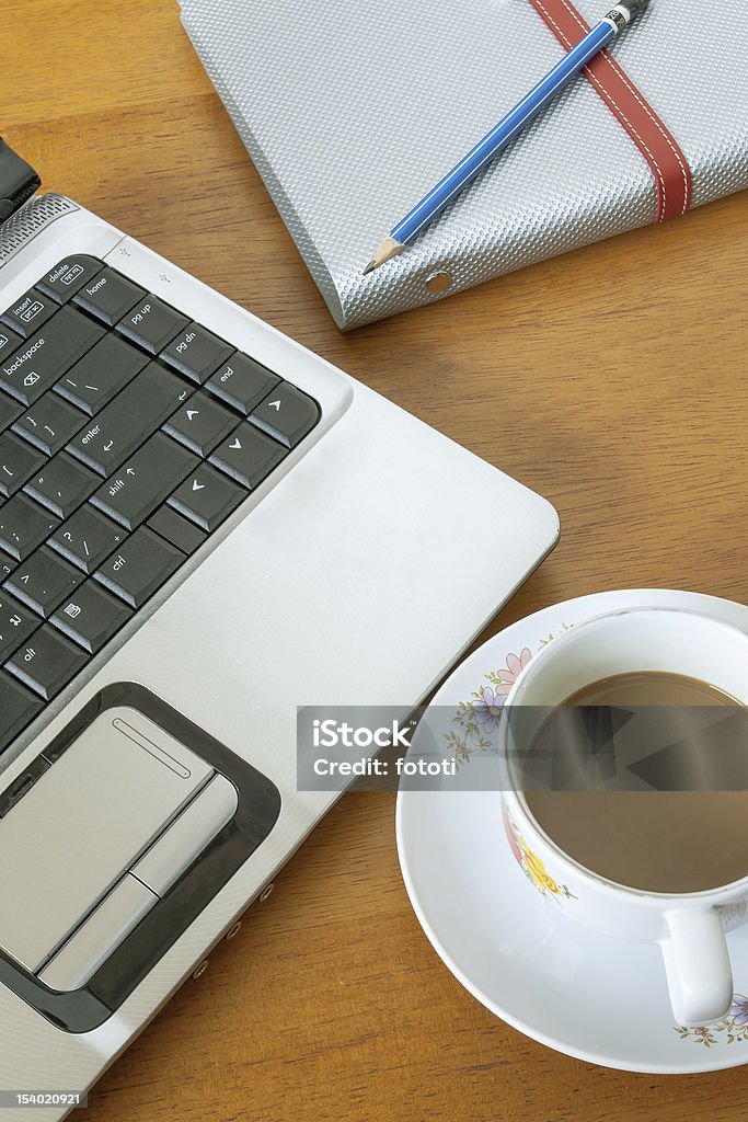 Tazza di caffè e notebook su sfondo in legno - Foto stock royalty-free di Bibita