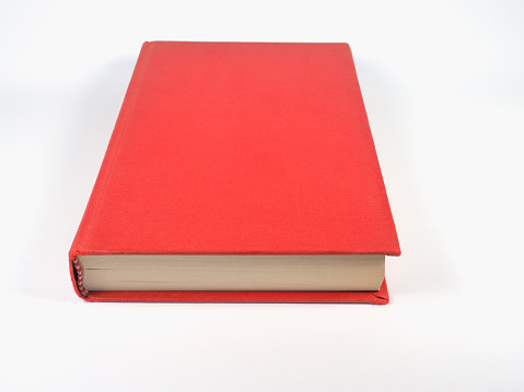 closed red book over off white background with copy space