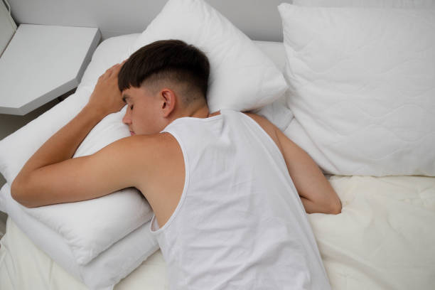 istock Young Man Sleeping on Top of Bed 1540223157
