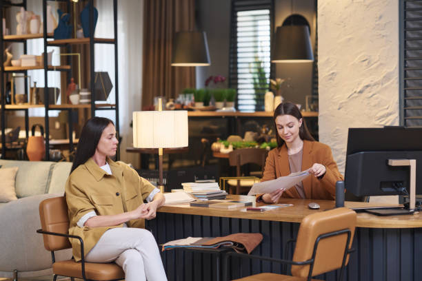 istock Young female client sitting in front of creative designer of interior 1540223738