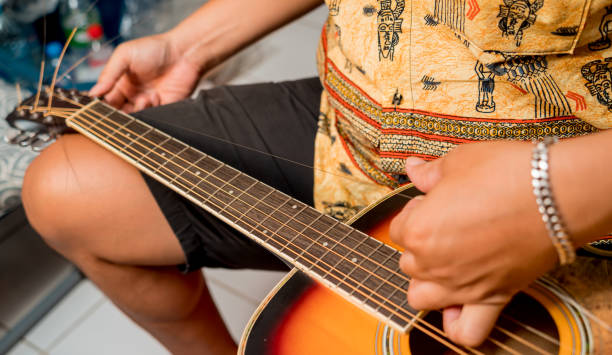 istock Young musician changing strings on a classical guitar in a guitar shop 1540242390