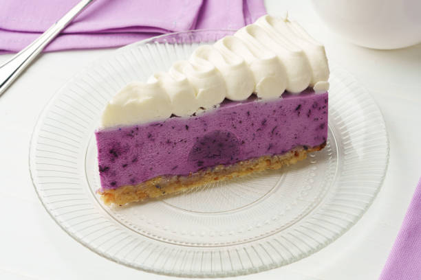Cut tasty blueberry cake on white table