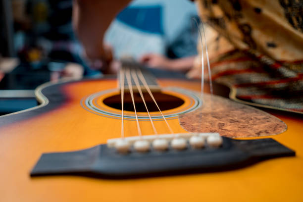 junger musiker wechselt saiten auf einer klassischen gitarre in einem gitarrenladen - 16022 stock-fotos und bilder