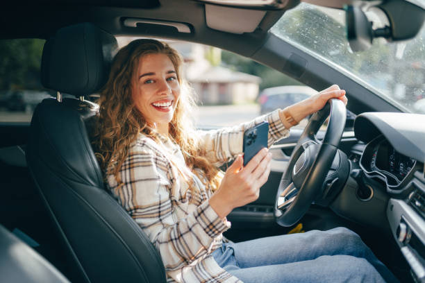 istock Young woman texting on her smartphone while driving a car 1540258880