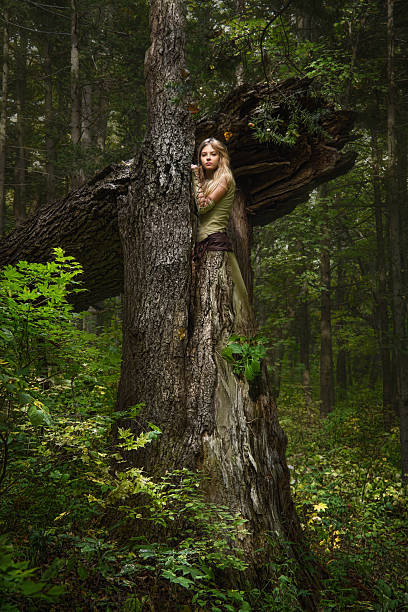 Blond girl dressed in dress walk in a magic forest