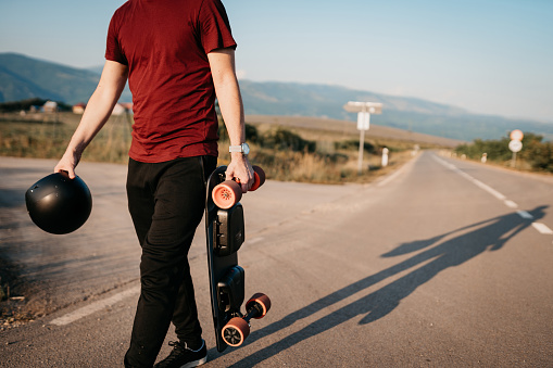 Young man using a electric skateboard on a square