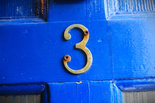 on an old blue timber door is the number 3