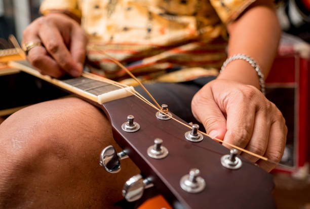 istock Young musician changing strings on a classical guitar in a guitar shop 1540284912