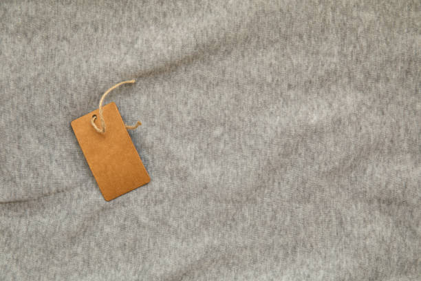 istock Gray heather fabric with paper label close up 1540288025