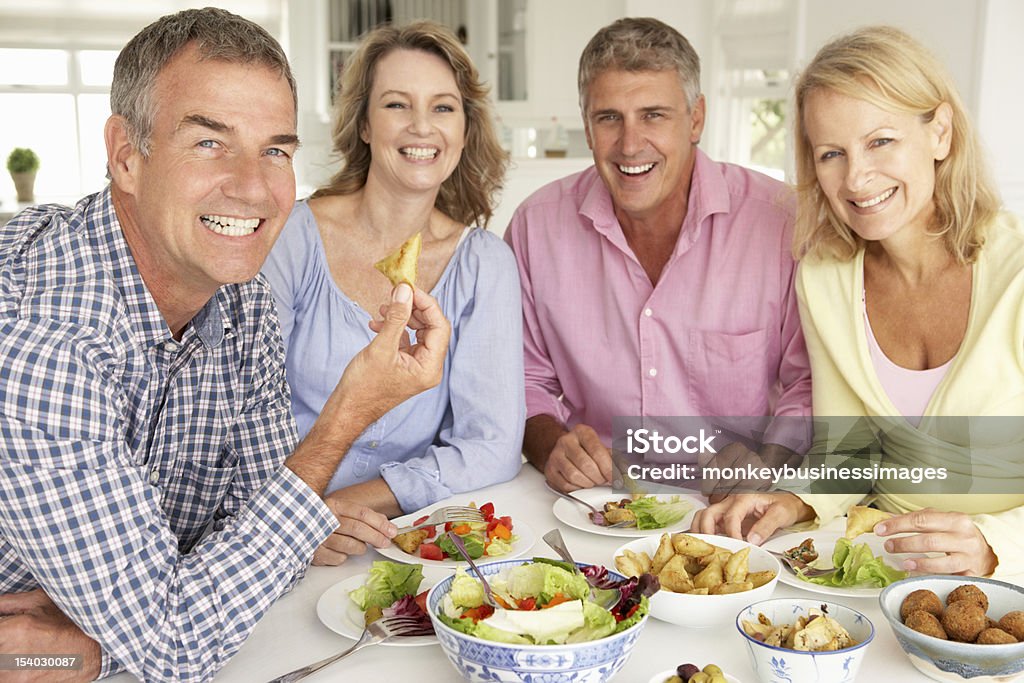 Pareja de mediana edad disfrutar de una comida en su hogar - Foto de stock de 50-59 años libre de derechos