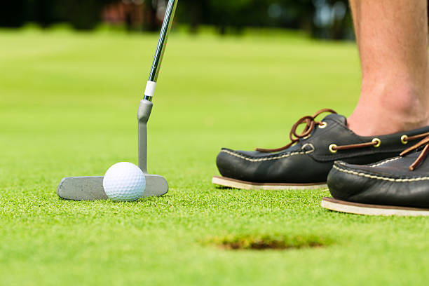 istock Golf player putting ball in hole 154032216