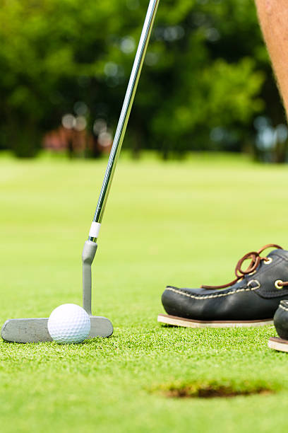 istock Golf player putting ball in hole 154032226