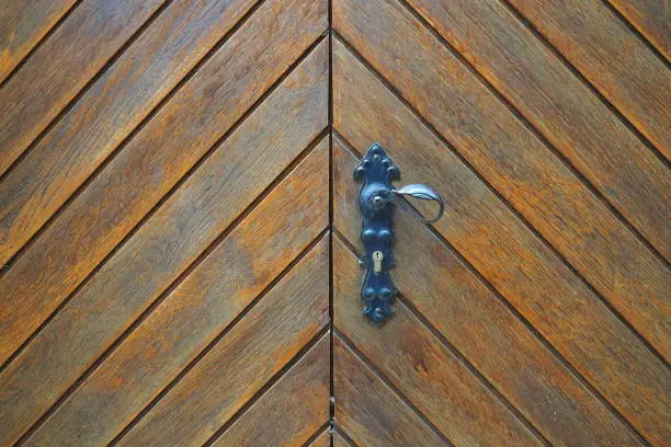 Old wooden door with antique door handle.