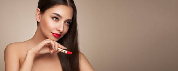 istock A beautiful young woman applying lipstick 1540324443