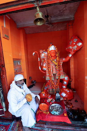 Haridwar, Uttarakhand, India –  May 02, 2023: Hindu devotee sitting in Lord Hanumana Temple at Haridwar, Uttrakhand, India.