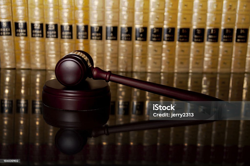 Judge gavel Judge gavel with blurred books in the background. Book Stock Photo