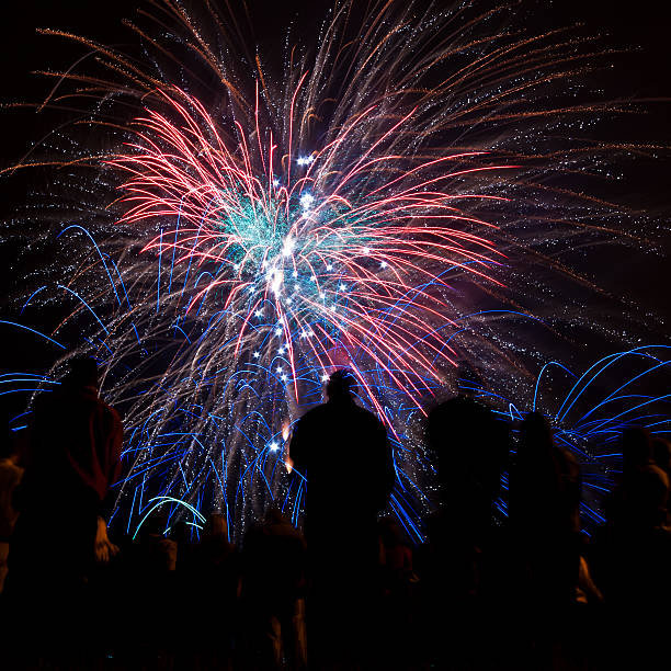 istock Big fireworks with silhouetted people in the foreground watching 154037933